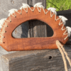 A wooden handle with white string on top of it.