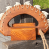 A wooden object with string and nail heads.