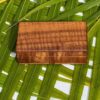 A wooden box sitting on top of a green leaf.